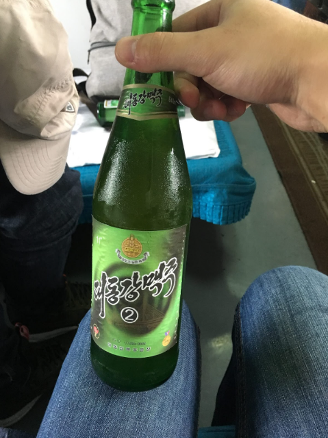 迫不及待開喝的大同江啤酒，上面的號碼是啤酒的等級，1號有著最好的品質，可惜這趟旅途中沒機會買到