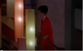 穿著紅色大衣的蘇麗珍急忙上樓梯貌。