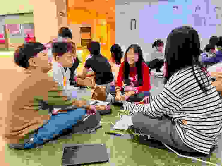 在新竹縣史館席地而坐，討論著等等要如何合作探索歷史的學生們。