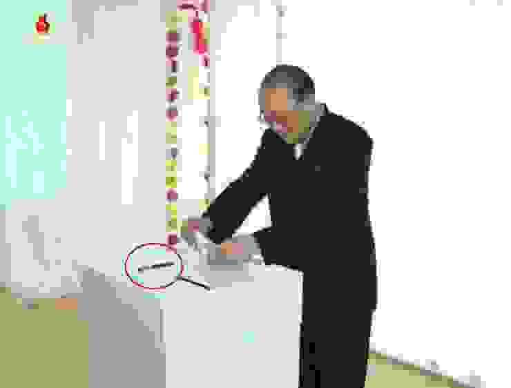 北韓選民在投票室投票，投票箱上放置原子筆（紅色圓圈）。〈朝鮮中央電視台，2015年畫面〉