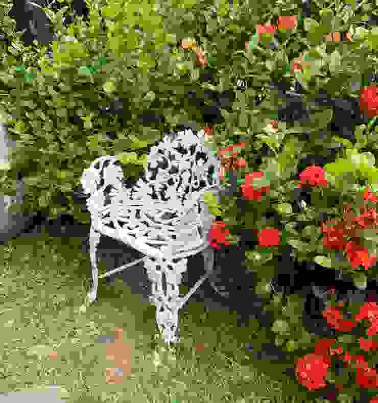 有點歷史及遭受自然鏽蝕的鐵椅，躲在綻放花叢裡，像是身處秘密花園的情境之中