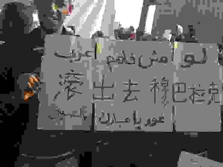 埃及革命街頭，拿著中文／阿拉伯文的抗爭民眾（photo by Essam Sharaf）