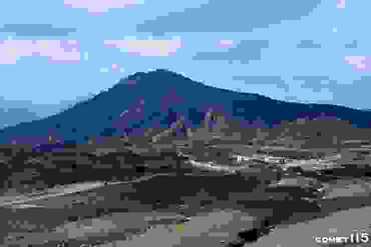 抵達山上公車總站後還要走公園道路（圖左）才能到達火山口，遠方的山峰為烏帽子岳