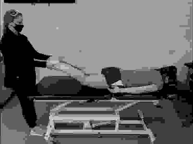 圖4:趴姿，施測者抬起選手的雙腳同時拉向自己(做出traction的動作)。若會疼痛，就是 陽性反應。