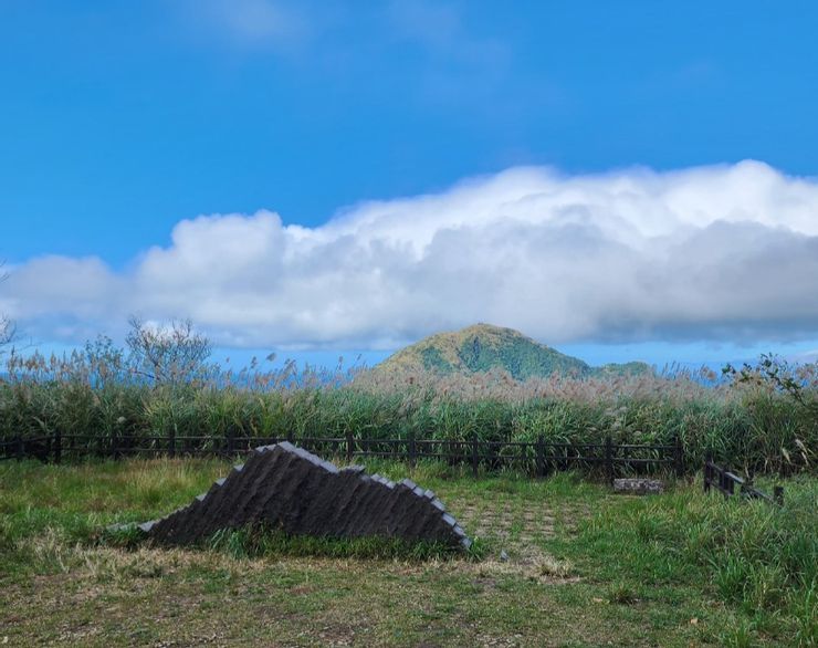由於取景的角度，前景的小山似乎不小於背後的基隆山，該山在雲霧繚繞中頗有富士山的架勢。