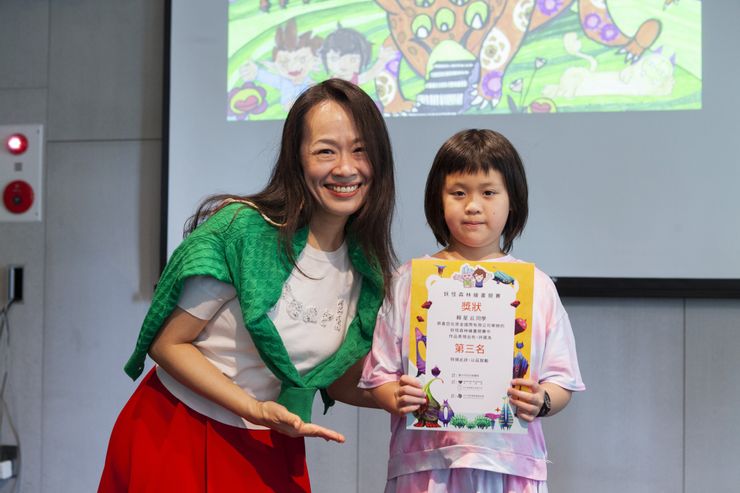 心之谷永續教育園區創辦人文蓓蓓(左)頒發小畫家比賽第三名獎狀, 並與得獎的小畫家合影。