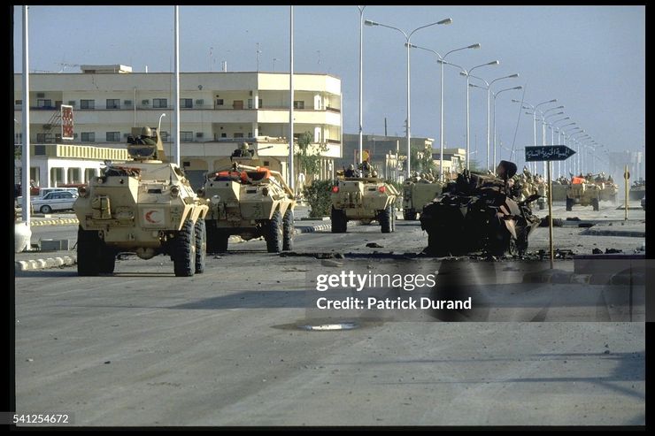 收復海夫吉的沙烏地國民衛隊V-150經過一輛遭到摧毀的同型車