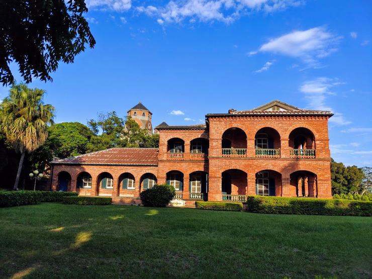 照片前方是台灣首座草地網球場。 由領事官邸側面可見建物前後分為三段。右段是客餐廳及主臥,中段是儲藏室、褓姆房及浴室,左段僅一層樓高的是僕役工作及休息空間,之間均有門予以區隔。